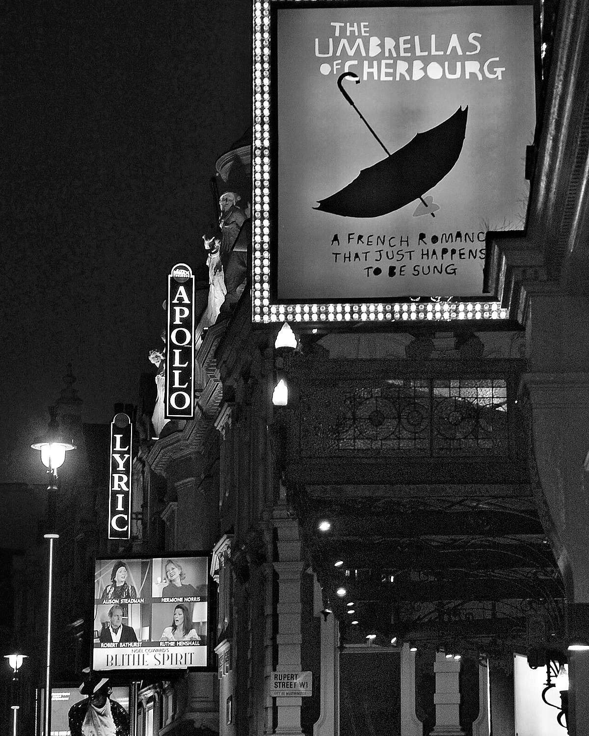 Theatre signs for the Apollo and the Lyric lit up at night on Shaftesbury Avenue in London’s West End