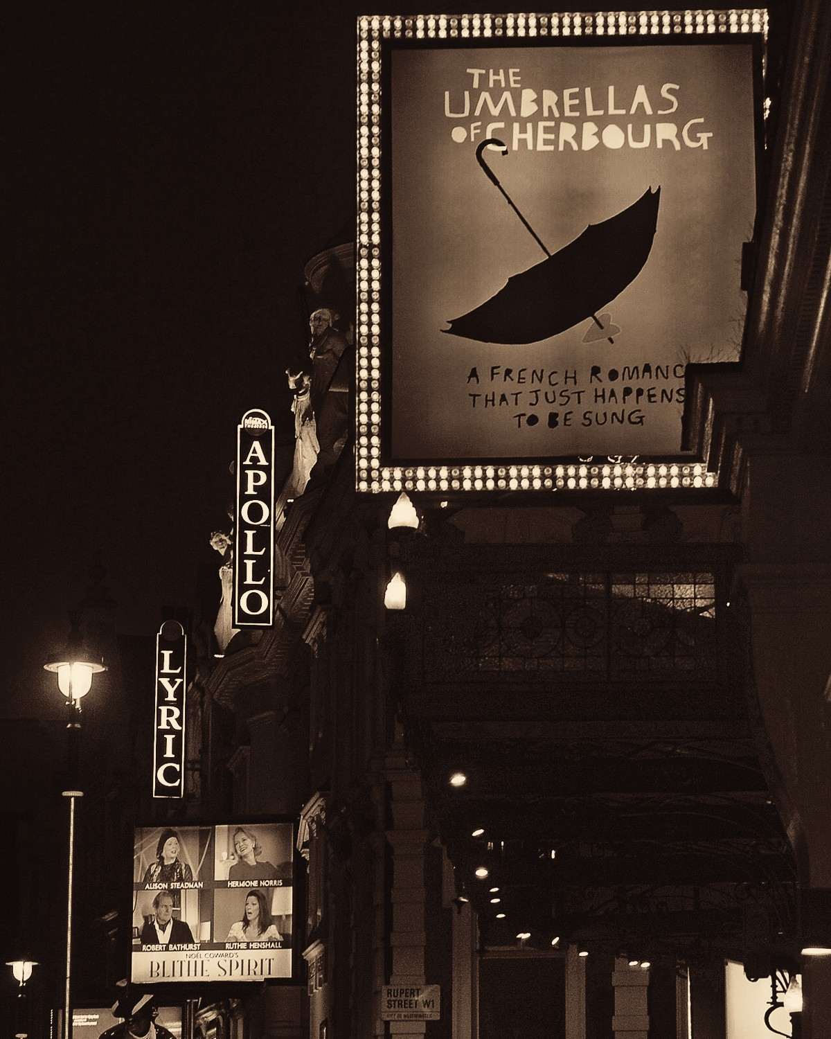Theatre signs for the Apollo and the Lyric lit up at night on Shaftesbury Avenue in London’s West End